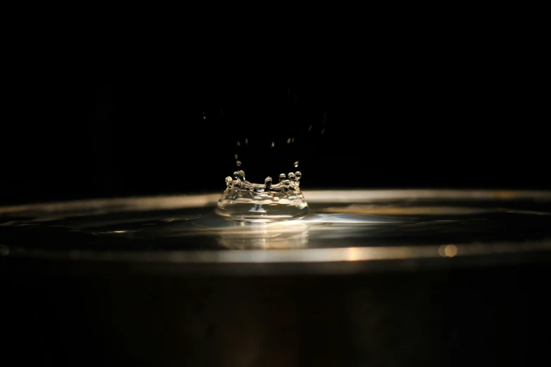 a clear drop in a metal pan on a black background
