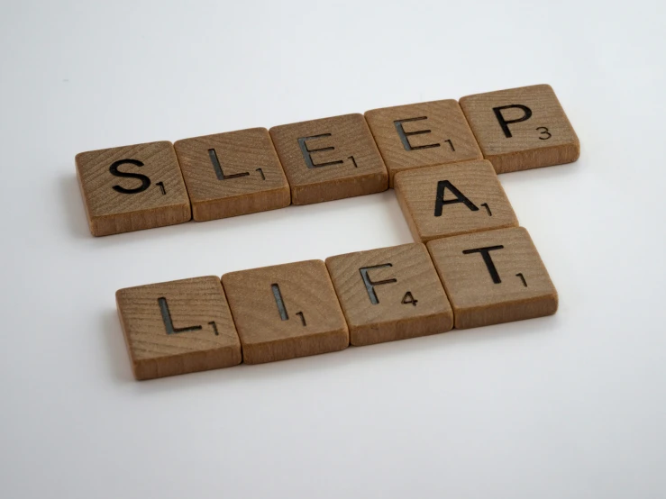 scrabbled wooden letters spelling the word sleep and eat