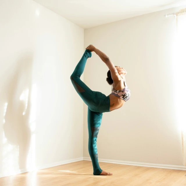 a man doing a hand stand in the middle of a wooden floor