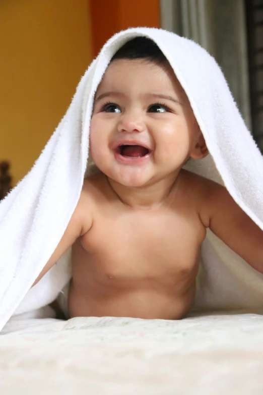 a  little boy with a towel over his head