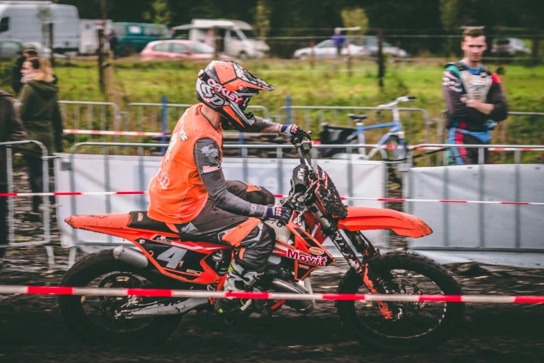 a dirt bike rider with his helmet up on the back wheel