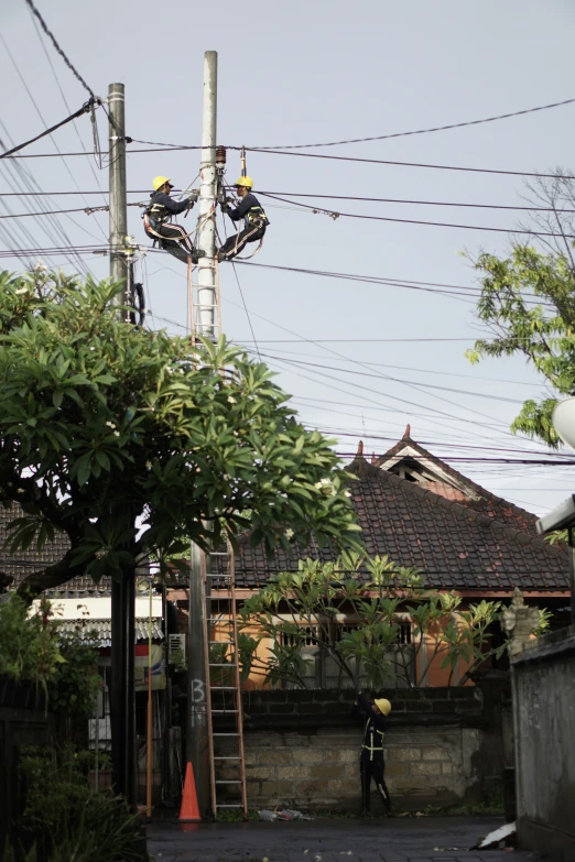 two electrical men are next to a street light