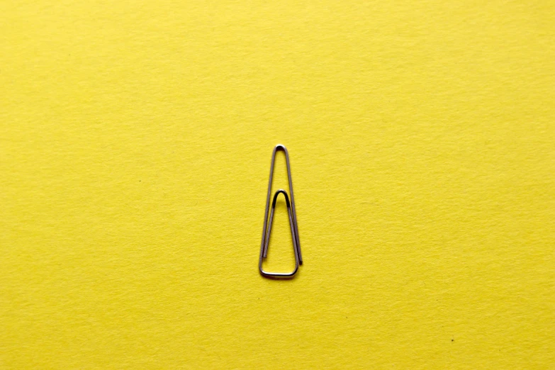 a pair of scissors lying on top of a yellow background
