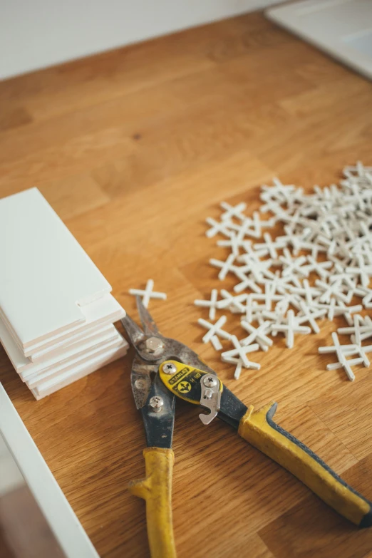 several small white snowflakes next to a pair of scissors