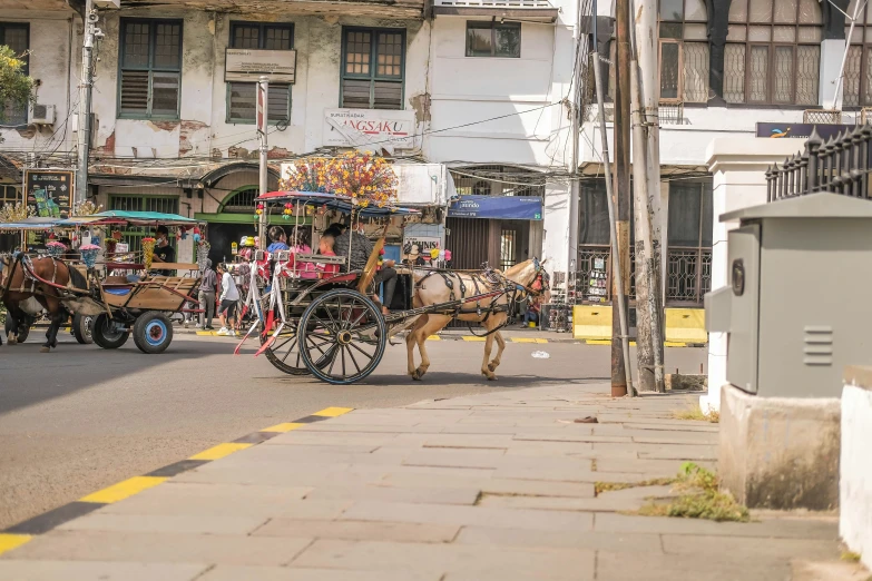 two horse drawn wagons in a busy city street