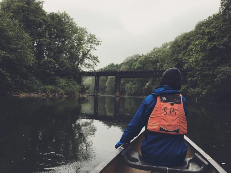 a man is paddling his canoe down the river