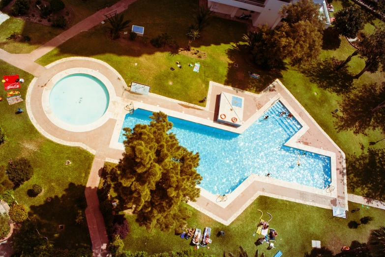 an aerial view of a swimming pool with trees