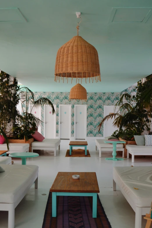 a room filled with lots of white furniture and green plants