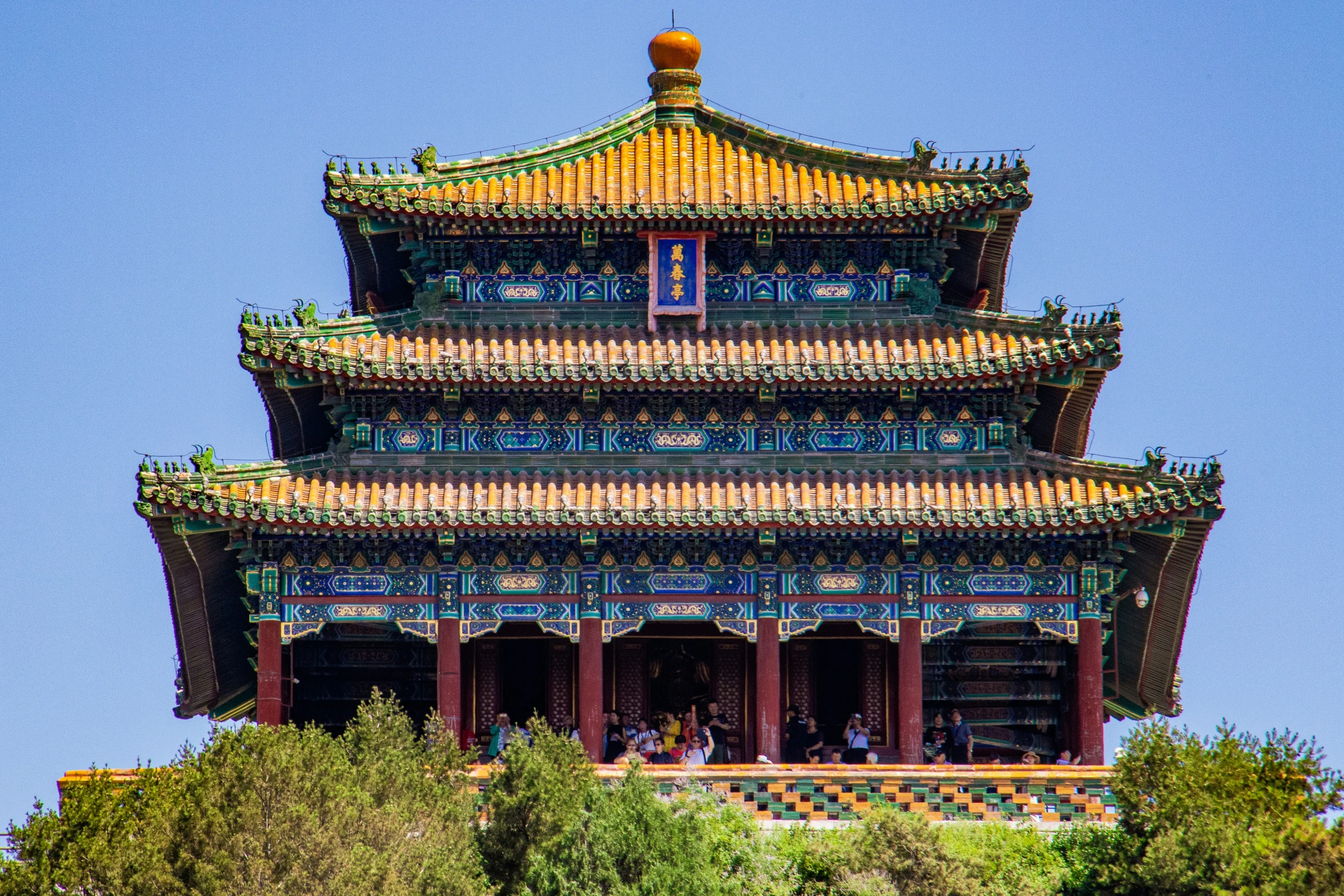 colorful oriental architecture stands tall behind some trees