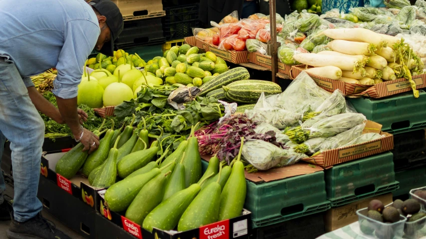 a man is standing next to boxes of produce