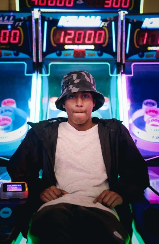 a  wearing a hat sitting in front of slot machines