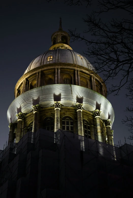 a very large building that has a gold dome and lights