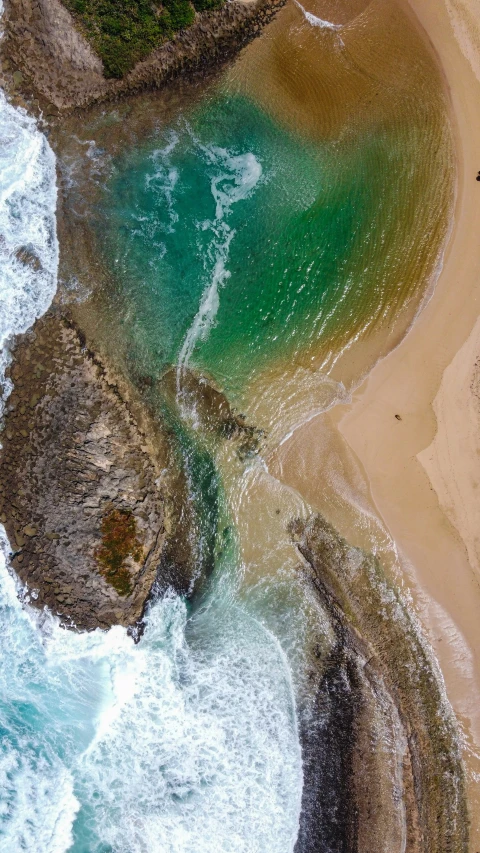 an aerial view of a sandy beach by the ocean