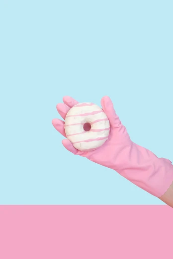 a person in pink gloves holding a donut
