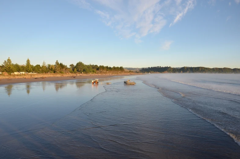 a few boats are out on the beach and water is calm