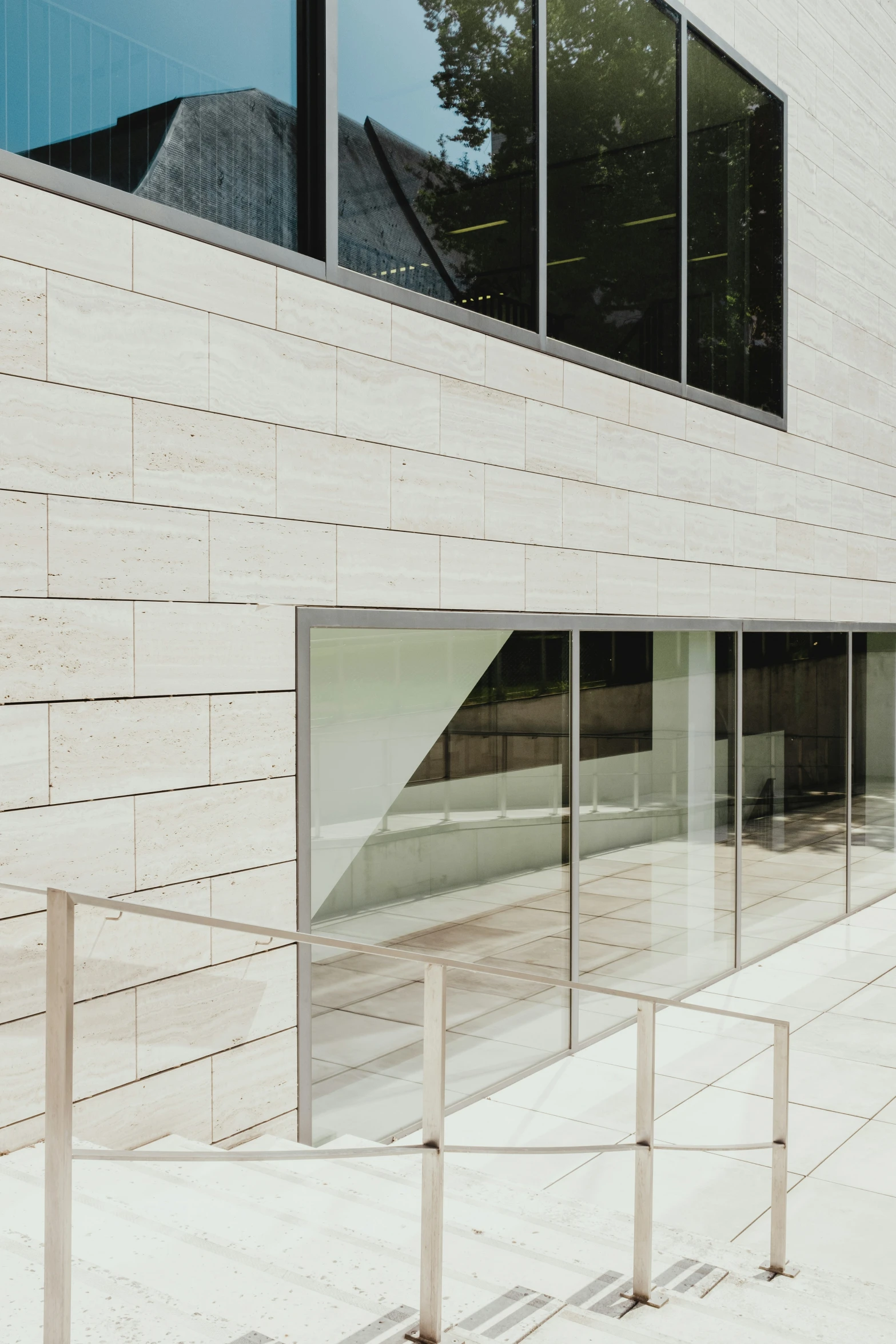 an empty concrete building is shown with tall glass windows