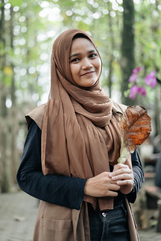 young woman in hijab holding a erfly in her hand