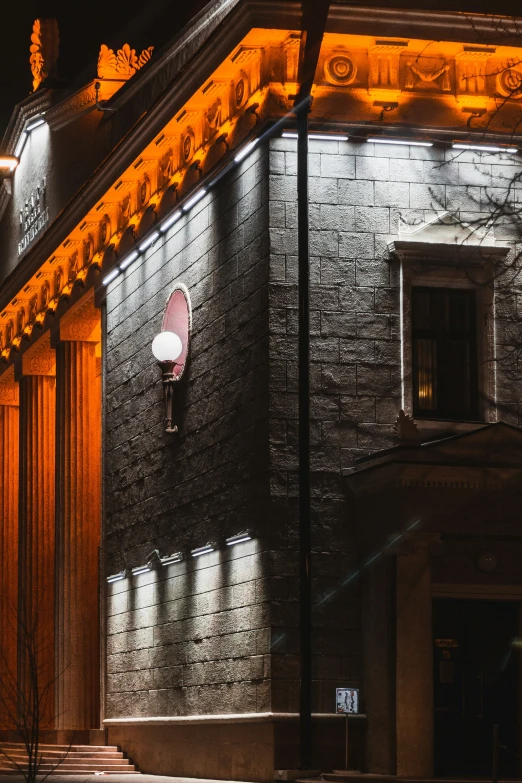 a night view of an elegant brick building with the moon in the window