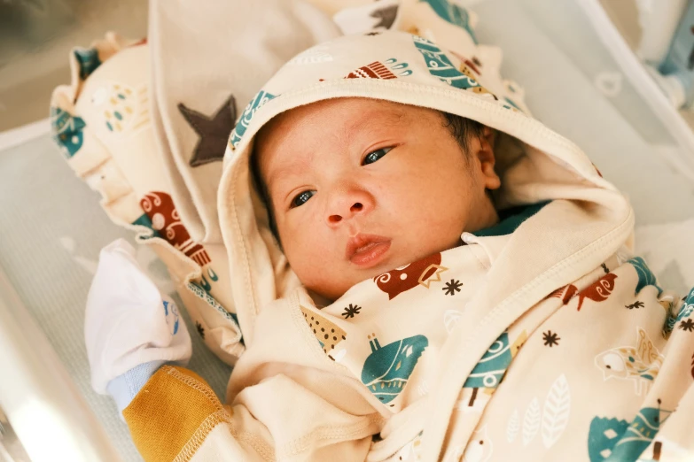 a newborn baby in a crib laying on his back