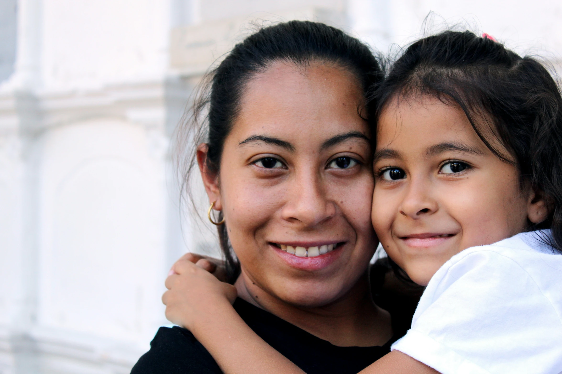 two women are hugging each other smiling