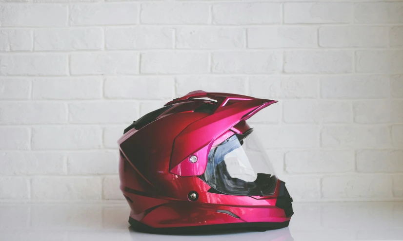 helmet with red visor sitting on top of a table