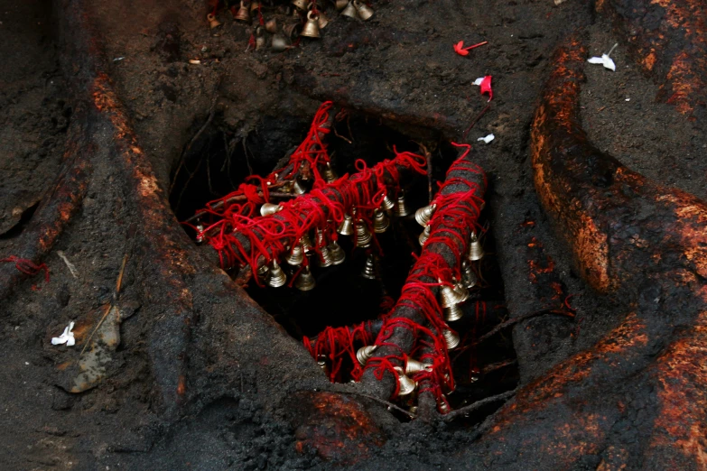 a bunch of bells sitting in a hole in the ground