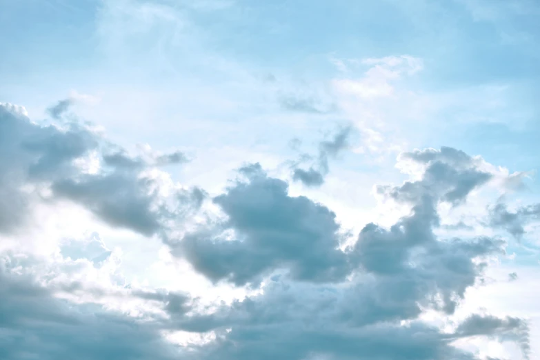 a plane flies high up in the sky with clouds