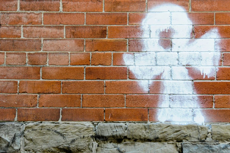 a wall with a brick wall and a painted angel