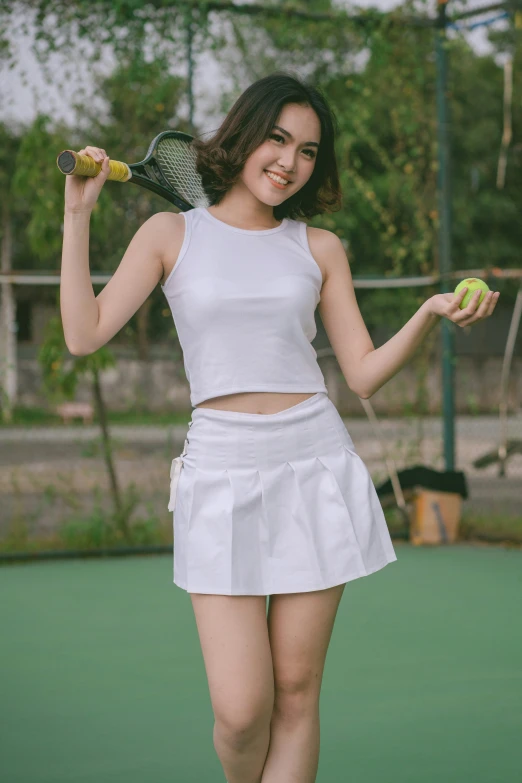 a woman holding two tennis balls in her hand and wearing a short skirt