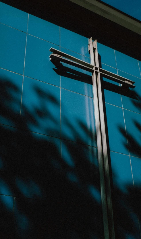 the shadow of a building on a tile wall with the cross