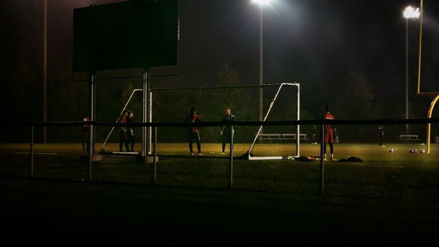 three soccer players are on a field playing with a goal