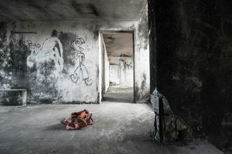 two persons on the floor of an empty building with graffiti