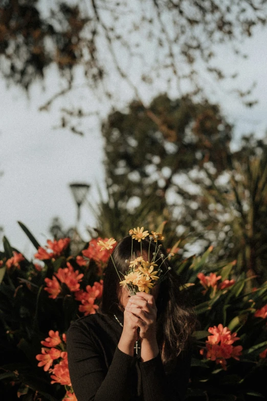 a woman that is kneeling down with flowers