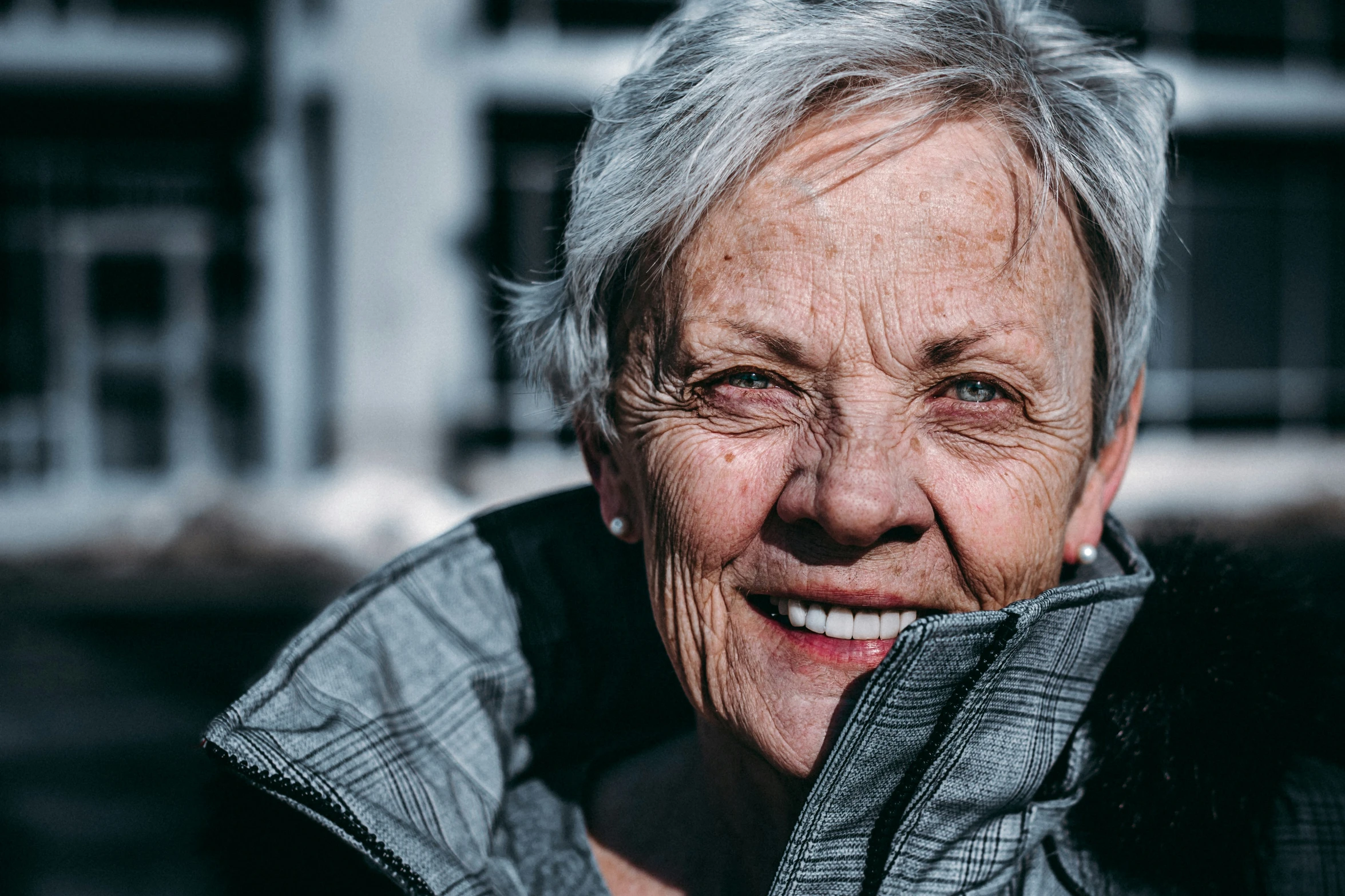 a woman with a jacket on smiles for the camera