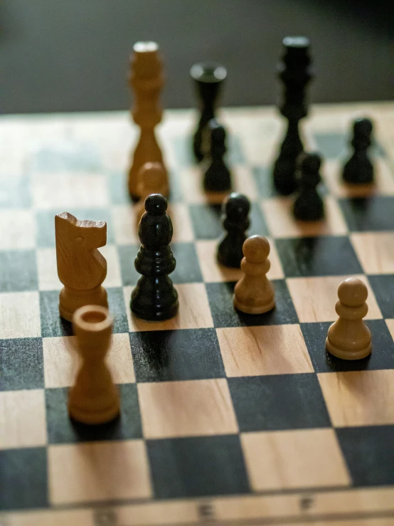 a close up view of chess pieces in brown and black on a checkerboard