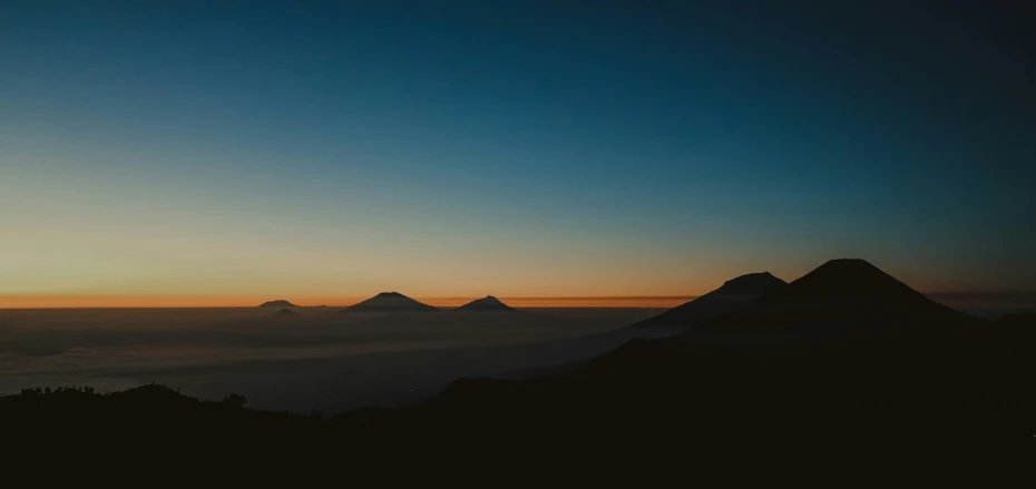 the top of some mountains as the sun rises