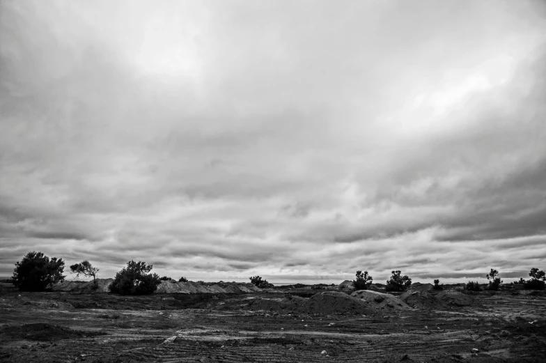 an empty field in front of some clouds