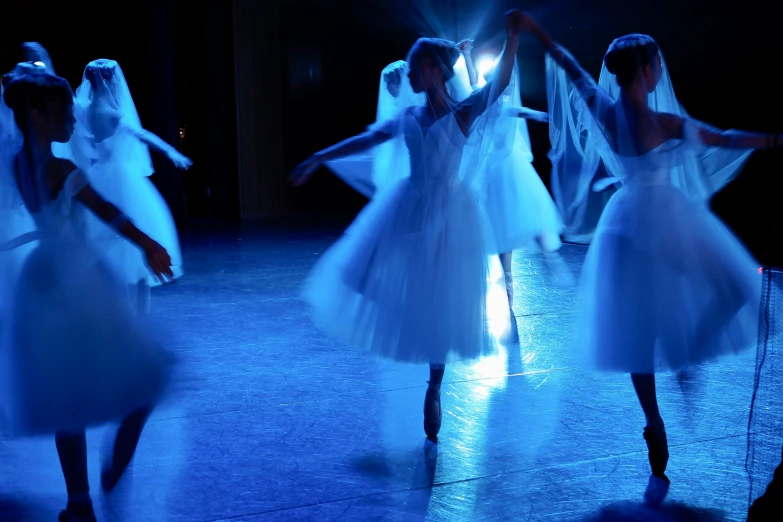 a group of dancers stand in the spotlight