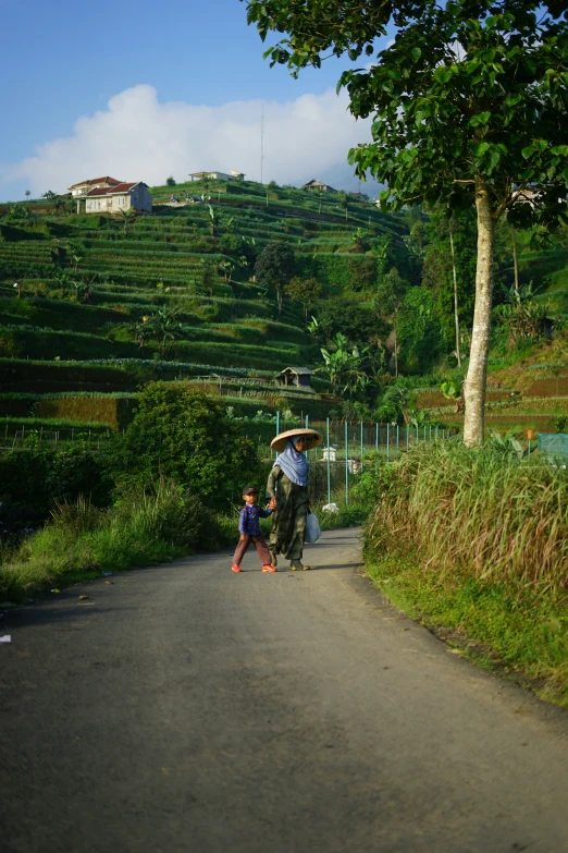 a man standing on the side of a road while holding a child