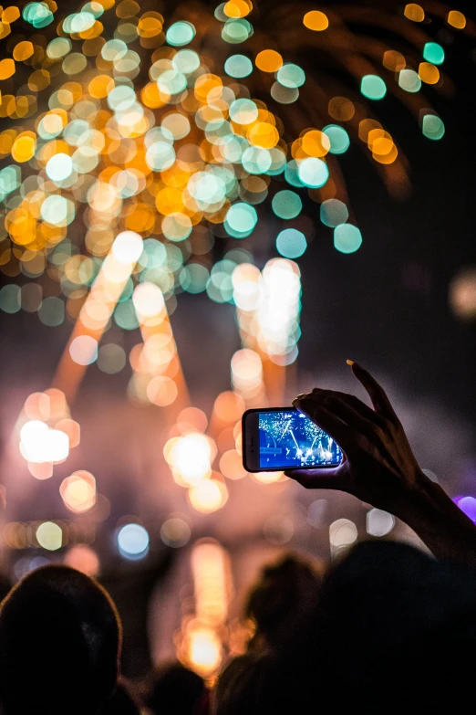 a group of people taking pictures of fireworks