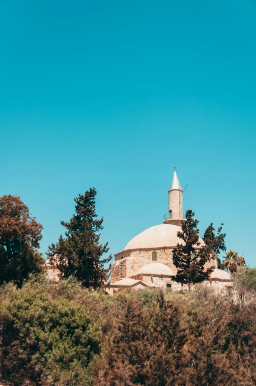 a church built on a hill surrounded by trees