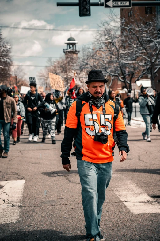 a man on the street is dressed in orange and grey