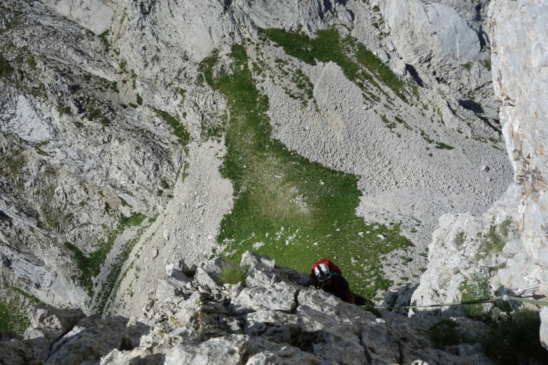 a hiker ascending a steep mountain slope to the top