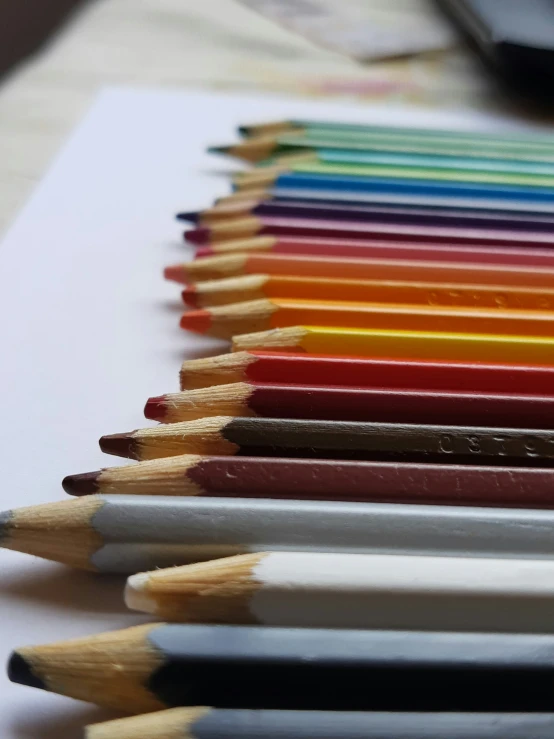 several different color pencils lined up and one is still attached