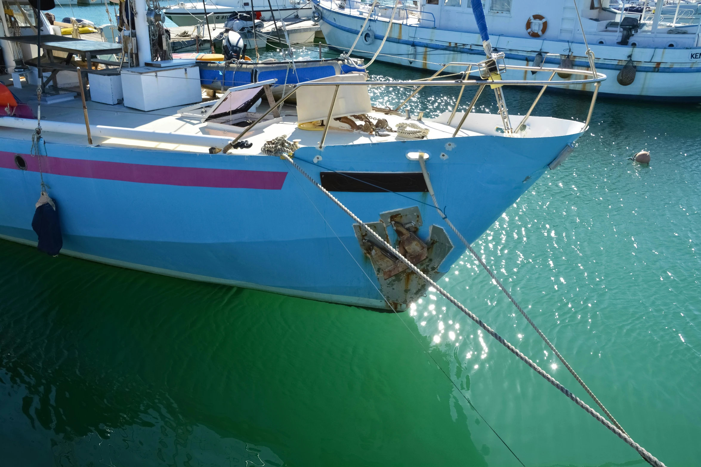 the colorful boat sits in the harbor with many others