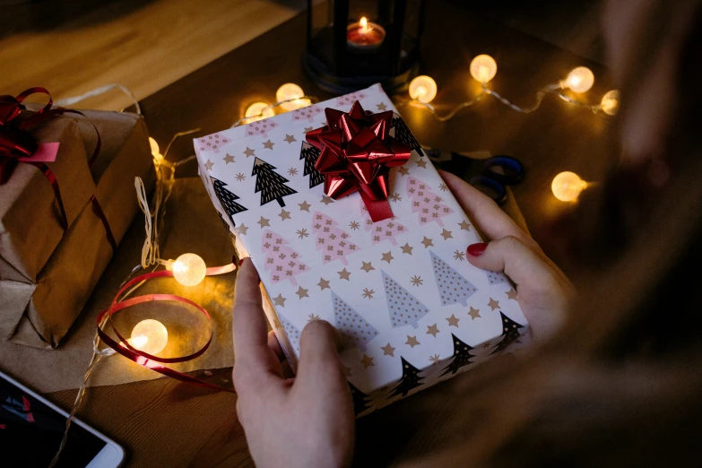 woman holding gift on table in decorated room