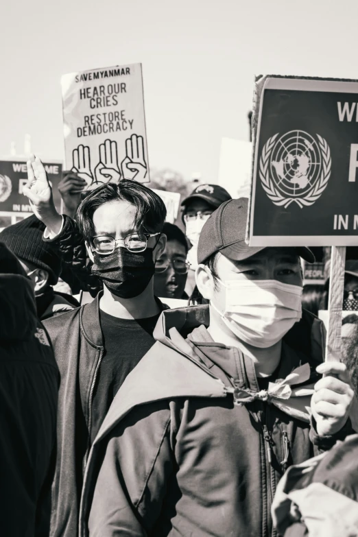 several people standing in the street and one wearing a mask