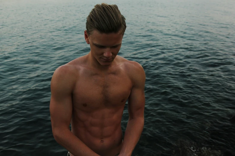 a man standing on the water holding a surfboard