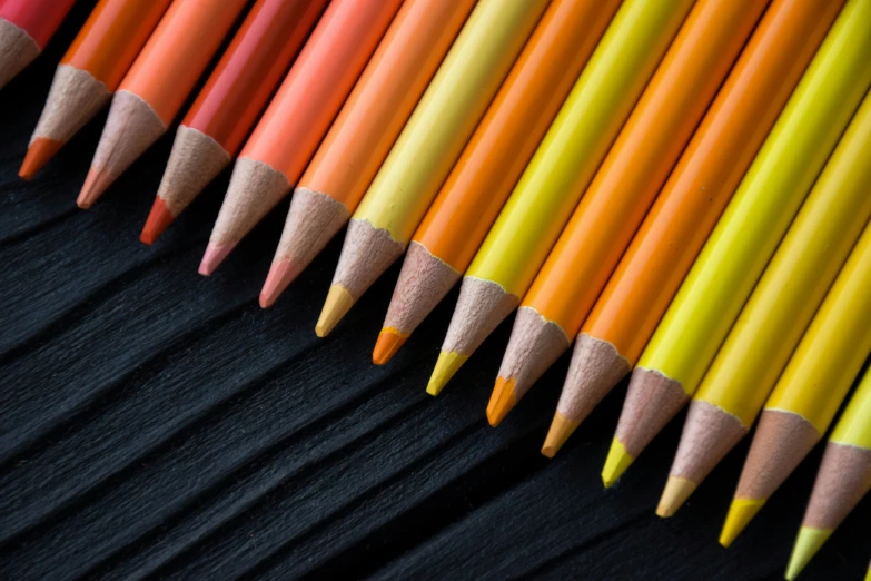 many orange and yellow pencils, lined up