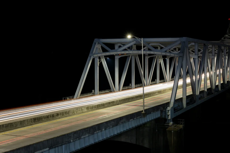 a night time po shows the traffic flowing over a large bridge